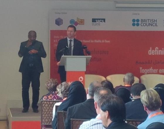 Chris standing at podium on stage at Definitely Able Conference in Doha